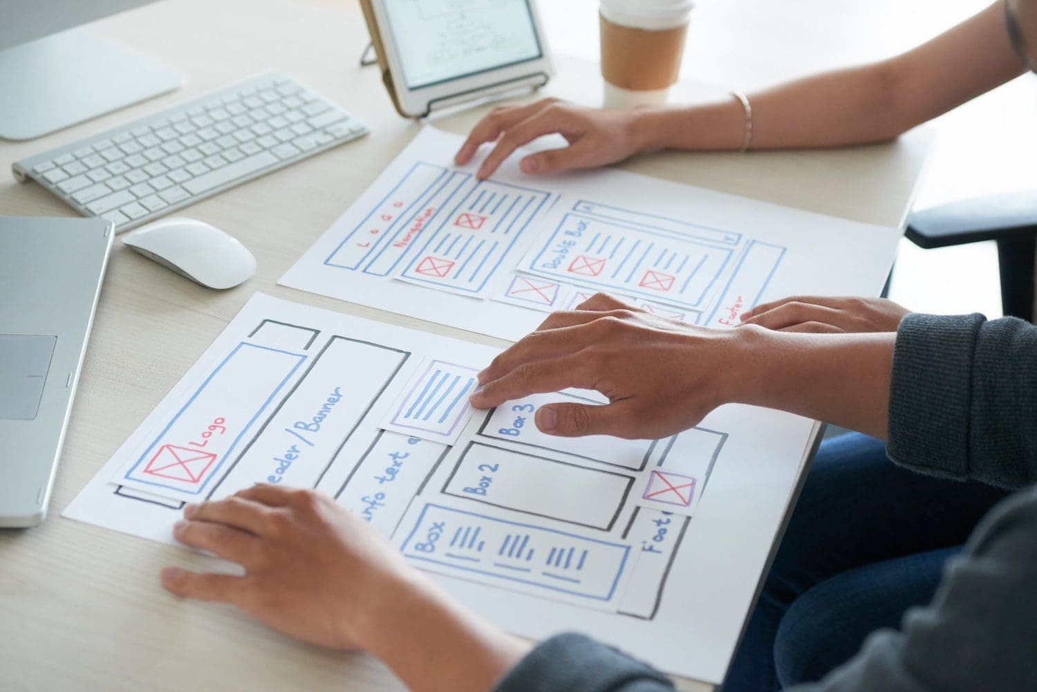 Programmers studying website layout on paper sheets